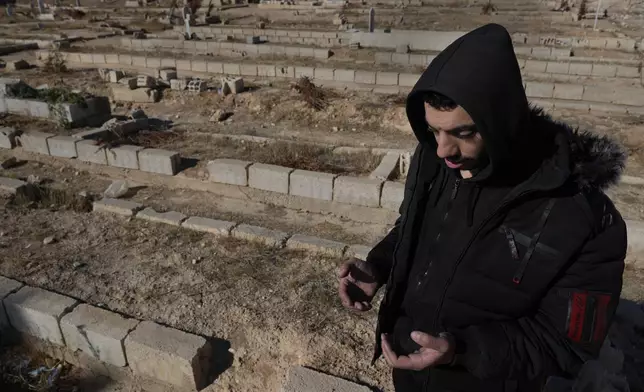 A Syrian man prays at a mass grave where they buried those who were killed by the sarin struck during a 2013 chemical weapons attack that was blamed on then President Bashar Assad's forces, in Zamalka neighbourhood, on the outskirts of Damascus, Syria, Wednesday, Dec. 25, 2024. (AP Photo/Hussein Malla)