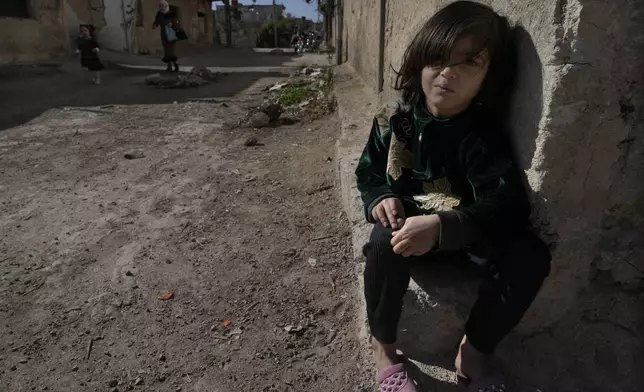 A Syrian girl sits next of her parent house, at an alley that was hit by the sarin struck during a 2013 chemical weapons attack that was blamed on then President Bashar Assad's forces, in Zamalka neighbourhood, on the outskirts of Damascus, Syria, Wednesday, Dec. 25, 2024. (AP Photo/Hussein Malla)