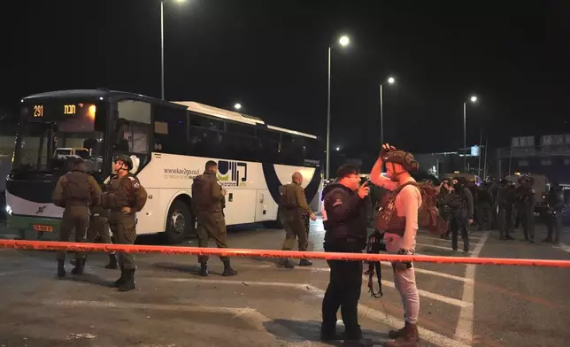 Israeli security forces work at the scene of a shooting attack on a bus near the West Bank town of Beit Jala, early Thursday, Dec. 12, 2024. (AP Photo/Mahmoud Illean)