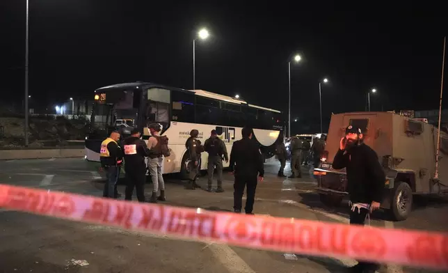 Israeli security forces work at the scene of a shooting attack on a bus near the West Bank town of Beit Jala, early Thursday, Dec. 12, 2024. (AP Photo/Mahmoud Illean)