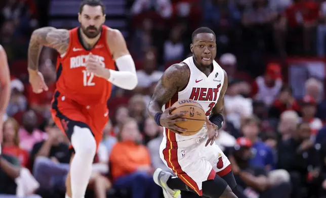 Miami Heat guard Terry Rozier III, right, drives down court in front of Houston Rockets center Steven Adams (12) during the first half of an NBA basketball game Sunday, Dec. 29, 2024, in Houston. (AP Photo/Michael Wyke)