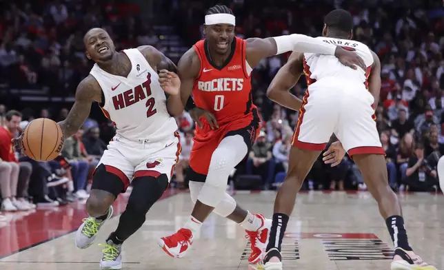 Miami Heat guard Terry Rozier III (2) drives around Houston Rockets guard Aaron Holiday (0) as Holiday is fouled on the illegal screen by guard Alec Burks, right, during the first half of an NBA basketball game Sunday, Dec. 29, 2024, in Houston. (AP Photo/Michael Wyke)