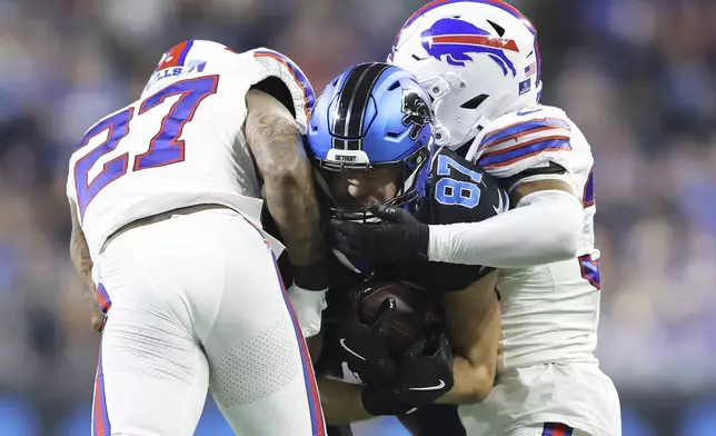 Detroit Lions tight end Sam LaPorta, middle, is tackled by Buffalo Bills safety Kareem Jackson (27) and cornerback Cam Lewis during the second half of an NFL football game, Sunday, Dec. 15, 2024, in Detroit. (AP Photo/Rey Del Rio)