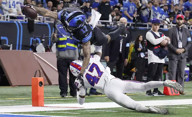 Detroit Lions wide receiver Tim Patrick (17) dives over Buffalo Bills cornerback Christian Benford (47) to score during the first half of an NFL football game, Sunday, Dec. 15, 2024, in Detroit. (AP Photo/Rey Del Rio)