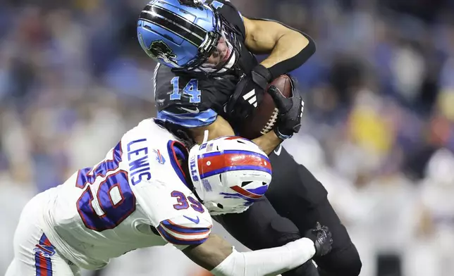 Detroit Lions wide receiver Amon-Ra St. Brown (14) is tackled by Buffalo Bills cornerback Cam Lewis (39) during the second half of an NFL football game, Sunday, Dec. 15, 2024, in Detroit. (AP Photo/Rey Del Rio)