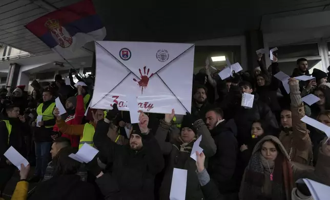 Students shout slogans during a protest protest that erupted after a concrete canopy fell last month and killed 15 people in front of the prosecutor's office in Belgrade, Serbia, Wednesday, Dec. 25, 2024. (AP Photo/Darko Vojinovic)