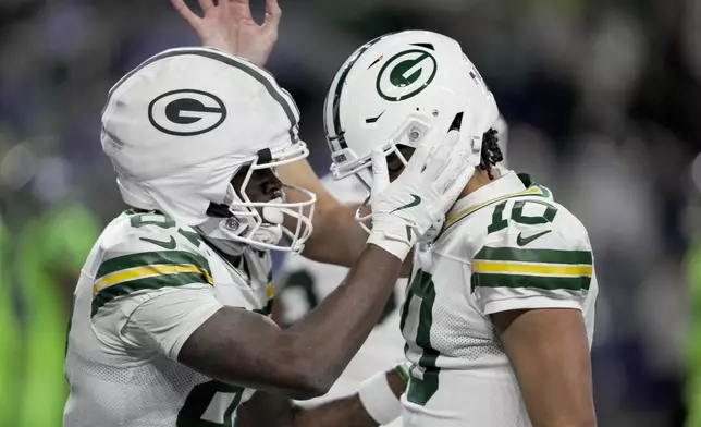 Green Bay Packers' Romeo Doubs celebrates his touchdown catch with Jordan Love during the second half of an NFL football game against the Seattle Seahawks Sunday, Dec. 15, 2024, in Seattle. (AP Photo/Stephen Brashear)