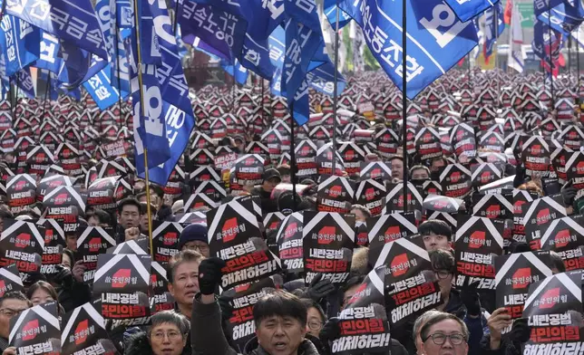 Protesters stage a rally to demand South Korean President Yoon Suk Yeol's impeachment in Seoul, South Korea, Thursday, Dec. 12, 2024. The signs read "Disband the ruling People Power Party." (AP Photo/Ahn Young-joon)