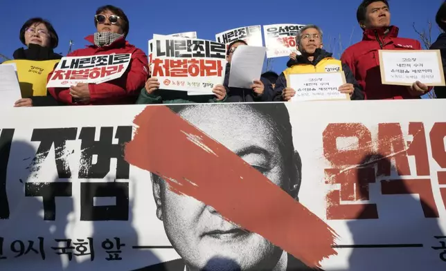 Protesters stage a rally to demand South Korean President Yoon Suk Yeol to step down in front of the National Assembly in Seoul, South Korea, Wednesday, Dec. 4, 2024. The signs read "Punish." (AP Photo/Ahn Young-joon)