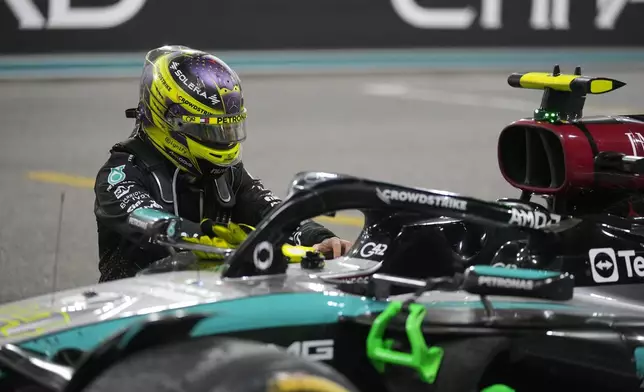 Lewis Hamilton of Britain kneels next to his car after his last race for the Mercedes team after the Formula One Abu Dhabi Grand Prix at the Yas Marina Circuit in Abu Dhabi, UAE, Sunday, Dec. 8, 2024. (AP Photo/Darko Bandic)