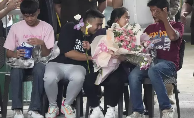 CORRECTS TO FAMILY INSTEAD OF SON AND HUSBAND - Mary Jane Veloso, second from right, a Filipino woman who spent almost 15 years in an Indonesian prison for drug trafficking and was nearly executed by firing squad in 2015, is reunited with her family as she arrives at the Correctional Institution for Women in Mandaluyong, Philippines Wednesday, Dec. 18, 2024. (AP Photo/Aaron Favila)