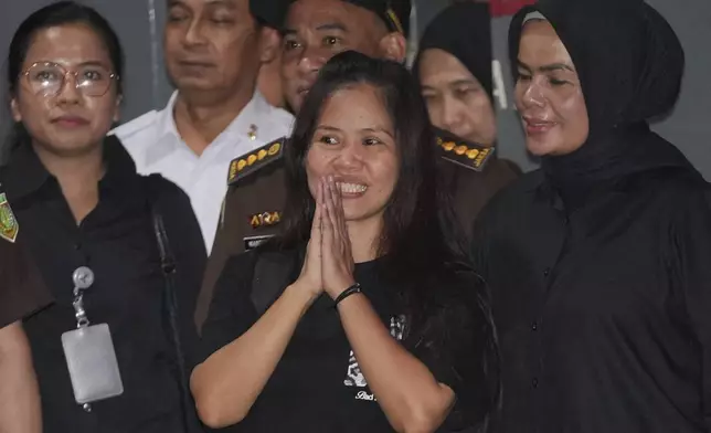 Filipino death row inmate Mary Jane Veloso, center, gestures at the media as she leaves Pondok Bambu Prison for Soekarno-Hatta International Airport in preparation for her repatriation to the Philippines, in Jakarta, Indonesia, Tuesday, Dec. 17, 2024. (AP Photo/Achmad Ibrahim)