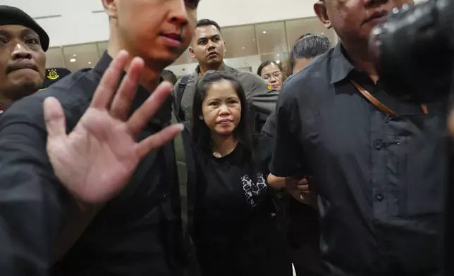 Mary Jane Veloso, center, a Filipina who was on death row in Indonesia and was nearly executed by firing squad in 2015, is escorted by Indonesian officials upon arrival at Soekarno-Hatta International Airport for her repatriation to the Philippines, in Tangerang, Indonesia, Tuesday, Dec. 17, 2024. (AP Photo/Tatan Syuflana)