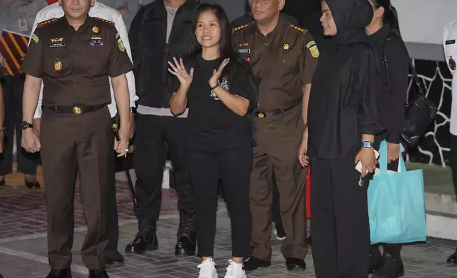 Filipino death row inmate Mary Jane Veloso, center, speaks to the media as she leaves Pondok Bambu Prison for Soekarno-Hatta International Airport in preparation for her repatriation to the Philippines, in Jakarta, Indonesia, Tuesday, Dec. 17, 2024. (AP Photo/Achmad Ibrahim)