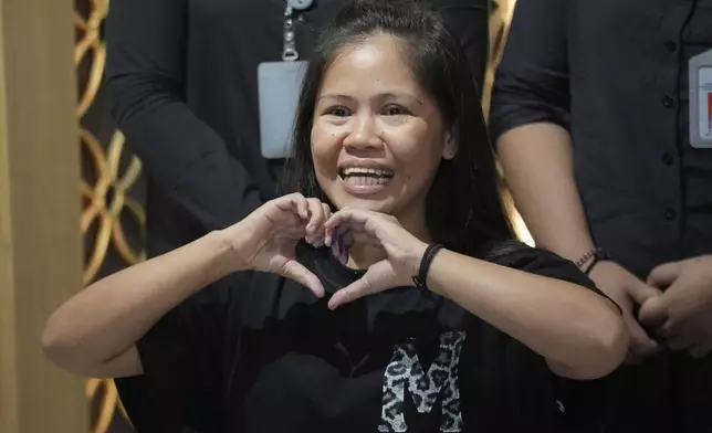 Mary Jane Veloso, a Filipina who was on death row in Indonesia and was nearly executed by firing squad in 2015, makes a heart sign during a press conference prior to her repatriation to the Philippines, at Soekarno-Hatta International Airport in Tangerang, Indonesia, Tuesday, Dec. 17, 2024. (AP Photo/Tatan Syuflana)