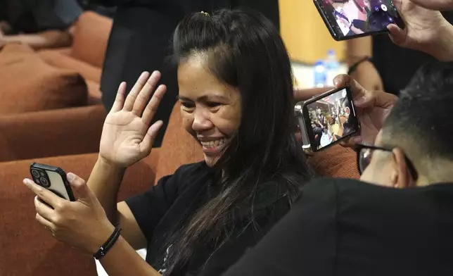 Mary Jane Veloso, center, a Filipina who was on death row in Indonesia and was nearly executed by firing squad in 2015, reacts as she uses a mobile phone for a video call after arrival at Soekarno-Hatta International Airport for her repatriation to the Philippines, in Tangerang, Indonesia, Tuesday, Dec. 17, 2024. (AP Photo/Tatan Syuflana)