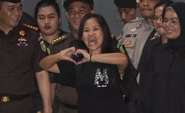 Filipino death row inmate Mary Jane Veloso, center, makes a heart sign as she leaves Pondok Bambu Prison for Soekarno-Hatta International Airport in preparation for her repatriation to the Philippines, in Jakarta, Indonesia, Tuesday, Dec. 17, 2024. (AP Photo/Achmad Ibrahim)