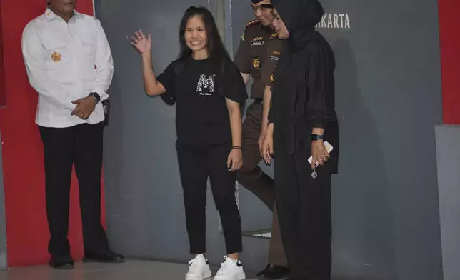 Filipino death row inmate Mary Jane Veloso, center, waves to the media as she leaves Pondok Bambu Prison for Soekarno-Hatta International Airport in preparation for her repatriation to the Philippines, in Jakarta, Indonesia, Tuesday, Dec. 17, 2024. (AP Photo/Achmad Ibrahim)