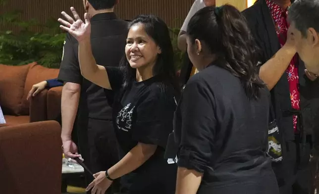 Mary Jane Veloso, center, a Filipina who was on death row in Indonesia and was nearly executed by firing squad in 2015, waves good bye after a press conference ahead of her repatriation to the Philippines, at Soekarno-Hatta International Airport in Tangerang, Indonesia, Tuesday, Dec. 17, 2024. (AP Photo/Tatan Syuflana)