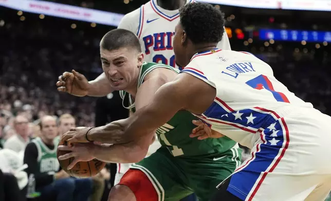 Philadelphia 76ers' Kyle Lowry (7) battles Boston Celtics' Payton Pritchard (11) for the ball during the first half of an NBA basketball game, Wednesday, Dec. 25, 2024, in Boston (AP Photo/Michael Dwyer)