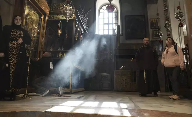 Worshippers visit the Church of the Nativity, where Christians believe Jesus Christ was born, ahead of Christmas in the West Bank city of Bethlehem, Tuesday, Dec. 17, 2024. (AP Photo/Mahmoud Illean)