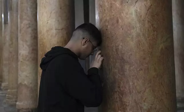 A worshipper visits the Church of the Nativity, where Christians believe Jesus Christ was born, ahead of Christmas in the West Bank city of Bethlehem, Tuesday, Dec. 17, 2024. (AP Photo/Mahmoud Illean)