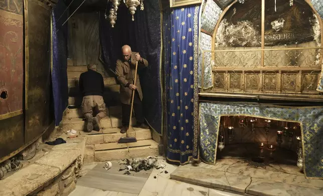 Workers in the Church of the Nativity, where Christians believe Jesus Christ was born, ahead of Christmas in the West Bank city of Bethlehem, Tuesday, Dec. 17, 2024. (AP Photo/Mahmoud Illean)