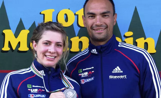 In this 2009 photo provided by Karen Gorman, biathlete Grace Boutot, left, of Fort Kent, Maine, displays her silver medal from the Youth Women Biathlon World Championships, while standing with coach Gary Colliander, right, in Fort Kent. (Karen Gorman via AP)