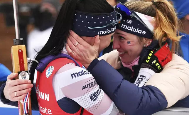 FILE — Joanne Reid, left, of the United States, and compatriot Deedra Irwin embrace at the finish line during the women's 4 x 6 km relay race at the biathlon World Cup in Anterselva, Italy, Jan. 22, 2022. (AP Photo/Matthias Schrader, File)