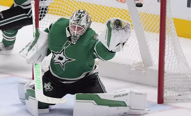 Dallas Stars goaltender Jake Oettinger gives up a goal to Minnesota Wild's Marcus Foligno during the third period of an NHL hockey game Friday, Dec. 27, 2024, in Dallas. (AP Photo/LM Otero)