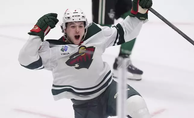 Minnesota Wild defenseman Brock Faber (7) celebrates scoring the winning goal in overtime of an NHL hockey game against the Dallas Stars Friday, Dec. 27, 2024, in Dallas. (AP Photo/LM Otero)