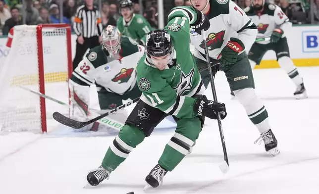 Dallas Stars center Logan Stankoven (11) skates for the puck in front of Minnesota Wild defenseman Brock Faber (7) and goaltender Filip Gustavsson (32) during the first period of an NHL hockey game Friday, Dec. 27, 2024, in Dallas. (AP Photo/LM Otero)
