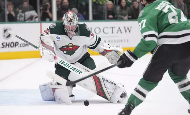 Minnesota Wild goaltender Filip Gustavsson (32) defends the goal against Dallas Stars left wing Mason Marchment (27) in the first period of an NHL hockey game Friday, Dec. 27, 2024, in Dallas. (AP Photo/LM Otero)