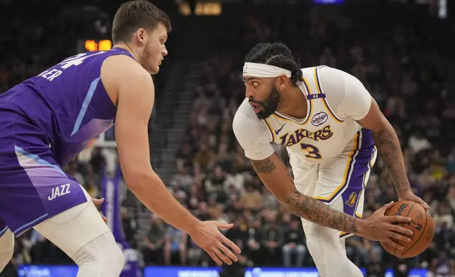 Los Angeles Lakers forward Anthony Davis (3) looks to pass the ball around Utah Jazz center Walker Kessler, left, during the first half of an NBA basketball game Sunday, Dec. 1, 2024, in Salt Lake City. (AP Photo/Bethany Baker)