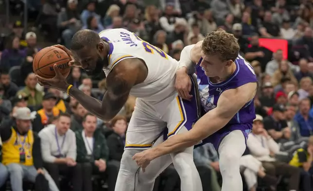 Los Angeles Lakers forward LeBron James (23) keeps the ball away from Utah Jazz forward Lauri Markkanen (23) during the second half of an NBA basketball game Sunday, Dec. 1, 2024, in Salt Lake City. (AP Photo/Bethany Baker)