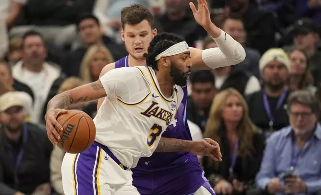 Utah Jazz center Walker Kessler fouls Los Angeles Lakers forward Anthony Davis as he drives to the basket during the second half of an NBA basketball game, Sunday, Dec. 1, 2024, in Salt Lake City. (AP Photo/Bethany Baker)