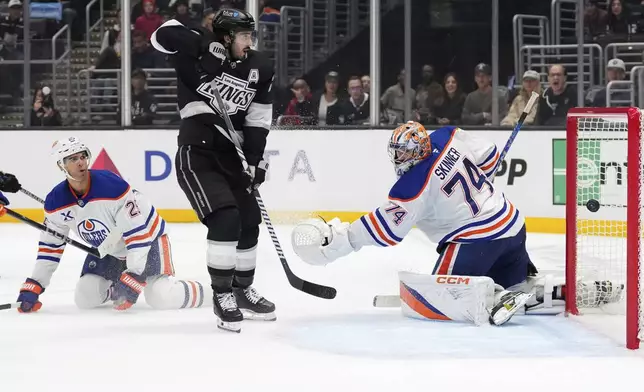 CORRECTS GAME PERIOD FROM THIRD TO OVERTIME - Edmonton Oilers goaltender Stuart Skinner, right, is scored on for the game-winning goal by Los Angeles Kings right wing Quinton Byfield, not seen, as defenseman Darnell Nurse, left, and center Phillip Danault watch during the overtime period of an NHL hockey game, Saturday, Dec. 28, 2024, in Los Angeles. (AP Photo/Mark J. Terrill)