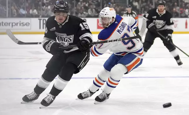 Los Angeles Kings center Alex Turcotte, left, and Edmonton Oilers center Connor McDavid go after the puck during the second period of an NHL hockey game, Saturday, Dec. 28, 2024, in Los Angeles. (AP Photo/Mark J. Terrill)