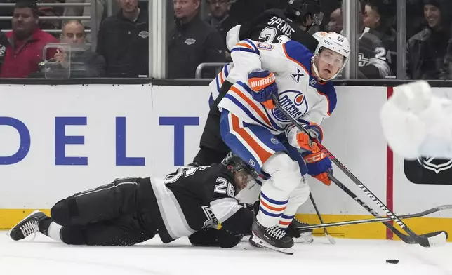 Edmonton Oilers center Mattias Janmark, right, takes the puck as Los Angeles Kings center Akil Thomas falls during the second period of an NHL hockey game, Saturday, Dec. 28, 2024, in Los Angeles. (AP Photo/Mark J. Terrill)