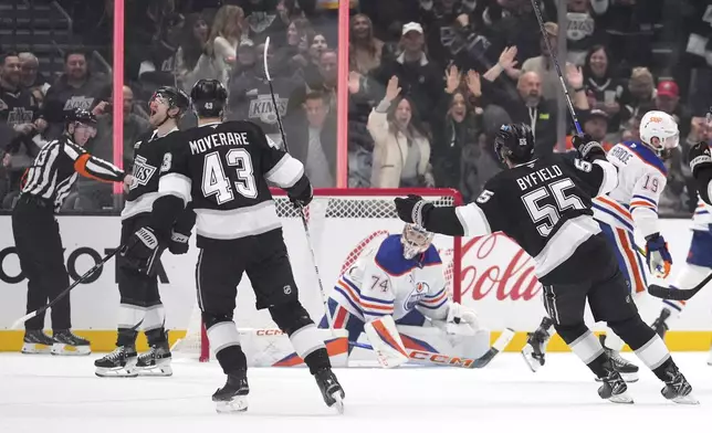 Los Angeles Kings left wing Warren Foegele, second from left, celebrates his goal along with defenseman Jacob Moverare, third from left, and right wing Quinton Byfield, second from right, as Edmonton Oilers goaltender Stuart Skinner, center watches during the first period of an NHL hockey game, Saturday, Dec. 28, 2024, in Los Angeles. (AP Photo/Mark J. Terrill)