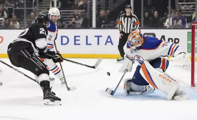 Edmonton Oilers goaltender Stuart Skinner, right, deflects a shot by Los Angeles Kings left wing Kevin Fiala during the second period of an NHL hockey game, Saturday, Dec. 28, 2024, in Los Angeles. (AP Photo/Mark J. Terrill)