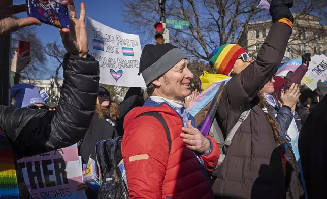 Joe Ronayne, of Cambridge, Mass., puts his hand on his heart while listening to an 11-year-old talk about her experiences as a trans girl, as he rallies with other supporters of transgender rights by the Supreme Court, Wednesday, Dec. 4, 2024, while arguments are underway in a case regarding a Tennessee law banning gender-affirming medical care for transgender youth. (AP Photo/Jacquelyn Martin)