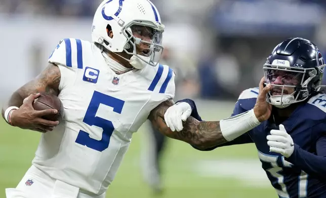 Indianapolis Colts quarterback Anthony Richardson (5) stiff arms Tennessee Titans safety Amani Hooker (37) as he runs the ball during the first half of an NFL football game Sunday, Dec. 22, 2024, in Indianapolis. (AP Photo/Darron Cummings)