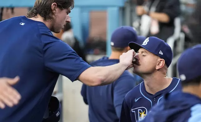 FILE - Tampa Bay Rays' Ryan Pepiot, left, adjusts the mustache of starting pitcher Tyler Alexander before a baseball game against the Los Angeles Dodgers in Los Angeles, Friday, Aug. 23, 2024. (AP Photo/Ashley Landis, File)