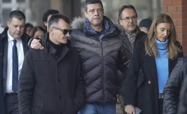 Relatives and friends of victims arrive in the court building prior to a verdict in trial of parents of a boy who killed 9 students and security guard in school shooting in 2023, in Belgrade, Serbia, Monday, Dec. 30, 2024. (AP Photo/Darko Vojinovic)