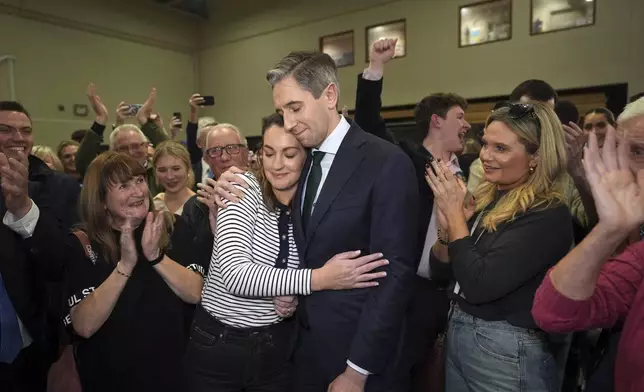 Irish premier Simon Harris is hugged by his wife Caoimhe after being re-elected to the Dail parliament as a TD for Wicklow on the first count at the election count centre at Shoreline Leisure Greystones in County Wicklow, south of Dublin, Ireland, after the General Election, Saturday, Nov. 30, 2024. (Niall Carson/PA via AP)
