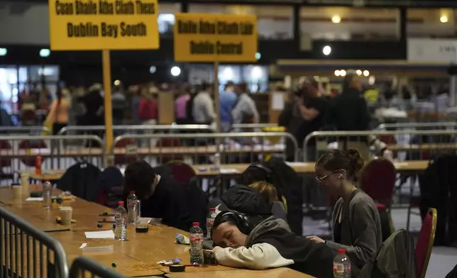 People take a break as the election count continues at RDS Simmonscourt after voters went to the polls during Ireland's election, in Dublin, Sunday, Dec. 1, 2024. (Brian Lawless/PA via AP)