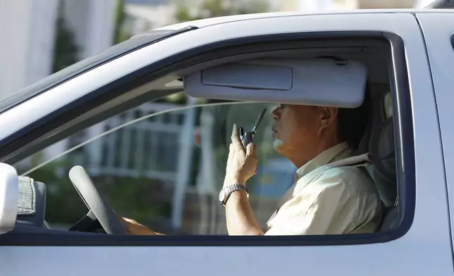 FILE - A man talks on his cell phone while driving in Los Angeles, Monday June 30, 2008. (AP Photo/Kevork Djansezian, File)