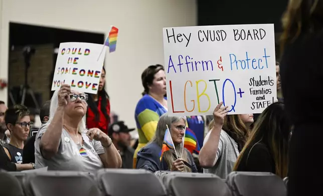 FILE - Parents, students, and staff of Chino Valley Unified School District hold up signs in favor of protecting LGBTQ+ policies at Don Antonio Lugo High School, in Chino, Calif., June 15, 2023. (Anjali Sharif-Paul/The Orange County Register via AP, File)