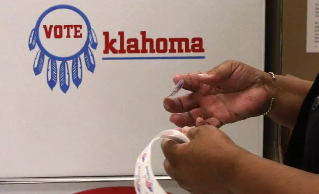 FILE - Election board inspector Pat Cook readies "I Voted" stickers for voters during early voting in Oklahoma City, Friday, Oct. 29, 2010. (AP Photo/Sue Ogrocki, File)